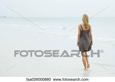 Woman in sundress walking at the beach, rear view View Large Photo Image Stock Image - Woman in sundress walking at the beach, rear view. Fotosearch