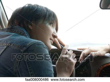 Woman leaning on steering wheel in car, friend's hand on dashboard View Large Photo Image Stock Photograph - Woman leaning on steering wheel in car, friend's hand on dashboard. Fotosearch