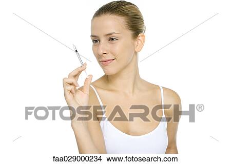 Woman looking at syringe, smiling View Large Photo Image Picture - Woman looking at syringe, smiling. Fotosearch