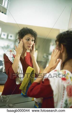 Picture - Woman looking in mirror. Fotosearch