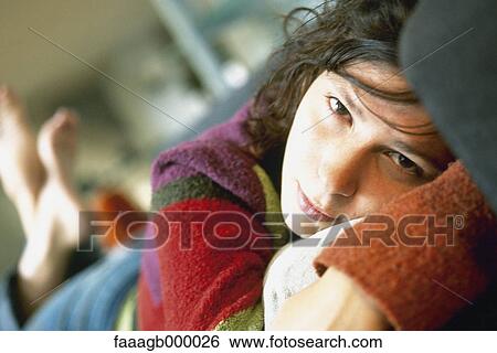 Woman lying on stomach, looking at camera View Large Photo Image Stock Photograph - Woman lying on stomach, looking at camera. Fotosearch