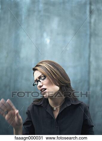 Woman making face and holding hand up View Large Photo Image Stock Image - Woman making face and holding hand up. Fotosearch