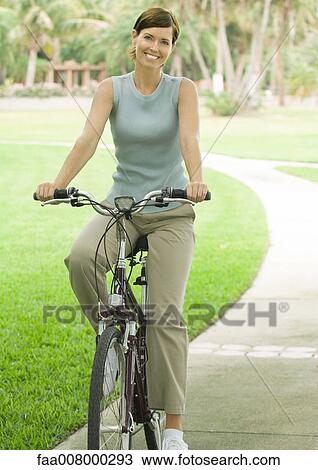 Woman on bike, smiling View Large Photo Image Stock Image - Woman on bike, smiling. Fotosearch
