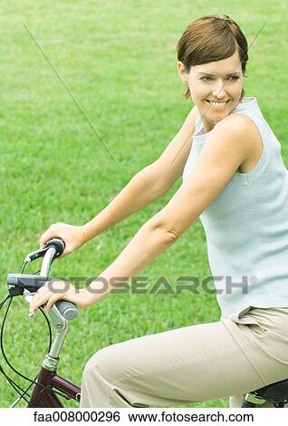 Woman on bike, smiling View Large Photo Image Stock Photograph - Woman on bike, smiling. Fotosearch