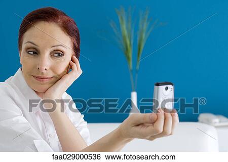 Woman photographing herself with photophone View Large Photo Image Stock Photograph - Woman photographing herself with photophone. Fotosearch