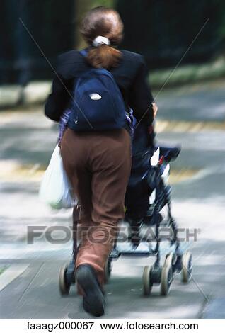 Woman pushing stroller View Large Photo Image Stock Photo - Woman pushing stroller. Fotosearch