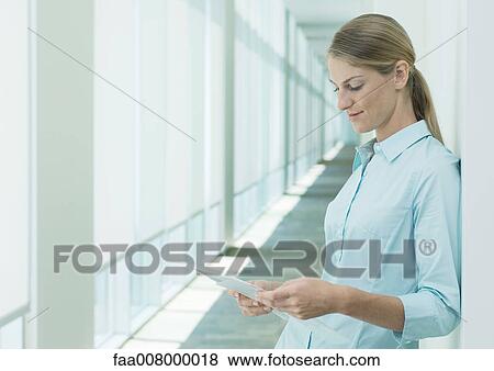 Woman reading document in hallway View Large Photo Image Stock Photo - Woman reading document in hallway. Fotosearch
