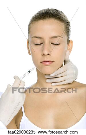 Stock Photography - Woman receiving Botox injection, eyes closed. Fotosearch