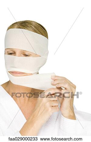 Woman removing bandages from face, looking away View Large Photo Image Stock Image - Woman removing bandages from face, looking away. Fotosearch