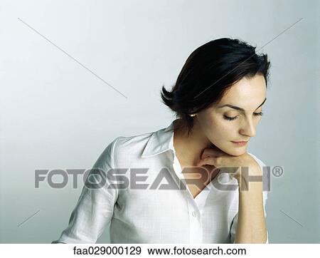 Woman resting chin on hand, looking down, portrait View Large Photo Image Stock Photo - Woman resting chin on hand, looking down, portrait. Fotosearch