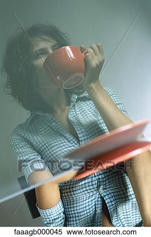 Woman sitting at table with cup View Large Photo Image Stock Photography - Woman sitting at table with cup. Fotosearch