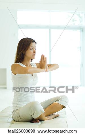 Woman sitting in lotus position, eyes closed View Large Photo Image Stock Photo - Woman sitting in lotus position, eyes closed. Fotosearch