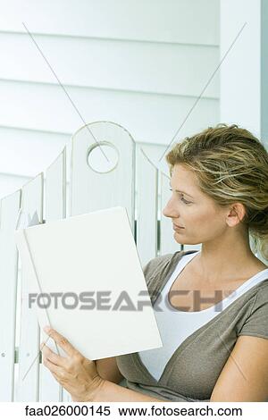Woman sitting on bench, reading book, side view View Large Photo Image Stock Photography - Woman sitting on bench, reading book, side view. Fotosearch