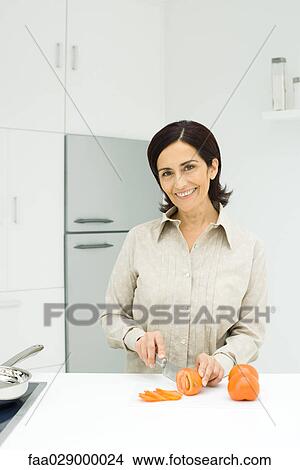 Woman slicing tomatoes in kitchen View Large Photo Image Picture - Woman slicing tomatoes in kitchen. Fotosearch