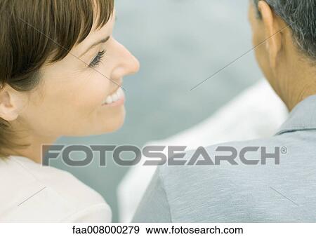 Woman smiling as man reads newspaper View Large Photo Image Stock Photo - Woman smiling as man reads newspaper. Fotosearch