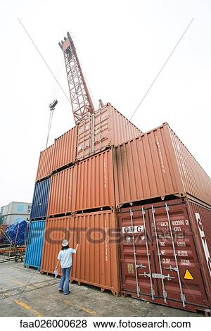 Woman standing in front of stacked industrial storage units, rear view View Large Photo Image Stock Photo - Woman standing in front of stacked industrial storage units, rear view. Fotosearch
