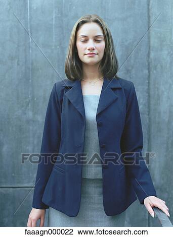 Woman standing with eyes half-closed, portrait View Large Photo Image Stock Image - Woman standing with eyes half-closed, portrait. Fotosearch