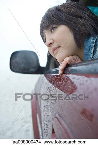 Woman sticking head out of car window in rainy weather View Large Photo Image Picture - Woman sticking head out of car window in rainy weather. Fotosearch