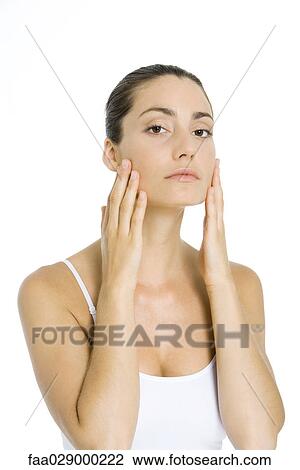 Woman touching cheeks with hands, looking at camera View Large Photo Image Stock Image - Woman touching cheeks with hands, looking at camera. Fotosearch