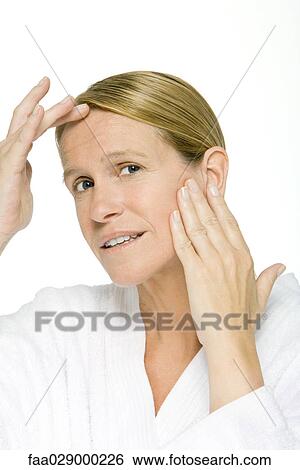 Woman touching forehead and cheek, close-up View Large Photo Image Stock Photograph - Woman touching forehead and cheek, close-up. Fotosearch