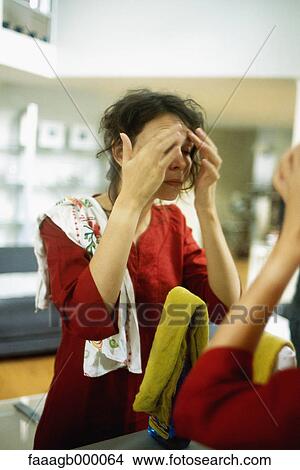 Woman touching forehead in front of mirror View Large Photo Image Picture - Woman touching forehead in front of mirror. Fotosearch