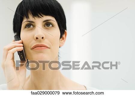 Woman using cell phone, looking up, close-up View Large Photo Image Stock Photo - Woman using cell phone, looking up, close-up. Fotosearch