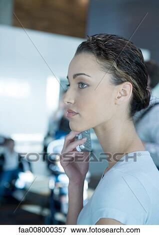 Stock Photo - Woman using cell phone, side view. Fotosearch