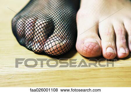Woman wearing fishnet stocking on one foot, patterned imprint on bare foot, extreme close-up View Large Photo Image Stock Photo - Woman wearing fishnet stocking on one foot, patterned imprint on bare foot, extreme close-up. Fotosearch