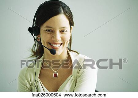 Woman wearing headset, smiling at camera, portrait View Large Photo Image Picture - Woman wearing headset, smiling at camera, portrait. Fotosearch