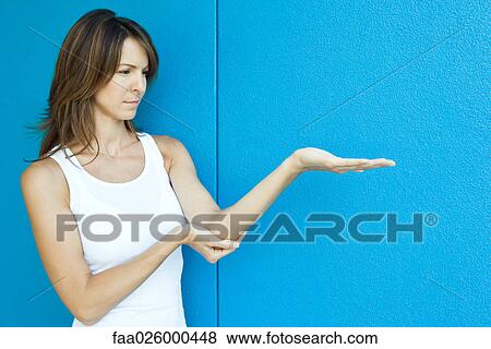 Woman with arm extended, one hand under elbow View Large Photo Image Stock Photo - Woman with arm extended, one hand under elbow. Fotosearch