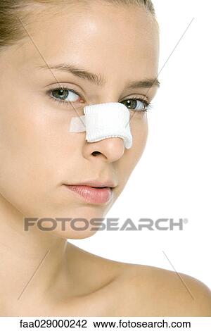 Woman with bandaged nose, looking at camera, close-up View Large Photo Image Stock Image - Woman with bandaged nose, looking at camera, close-up. Fotosearch