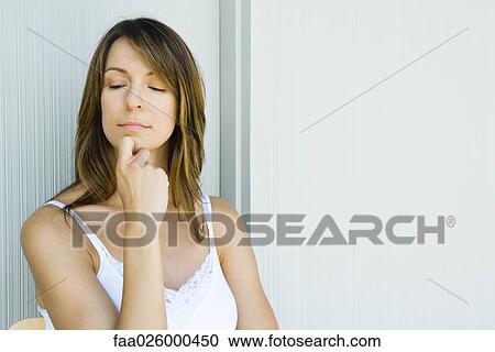 Woman with hand under chin, looking down, eyes half-opened View Large Photo Image Stock Image - Woman with hand under chin, looking down, eyes half-opened. Fotosearch
