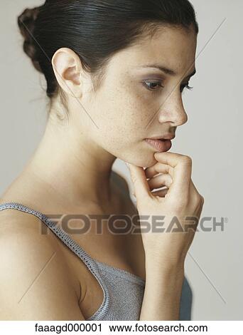 Stock Image - Woman with hand under chin, portrait. Fotosearch