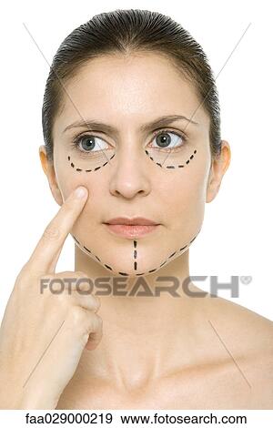 Woman with plastic surgery markings on face, pointing at cheek, looking away View Large Photo Image Stock Photo - Woman with plastic surgery markings on face, pointing at cheek, looking away. Fotosearch