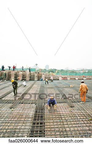 Workers building steel framework at construction site View Large Photo Image Picture - Workers building steel framework at construction site. Fotosearch