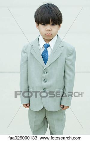 Young boy dressed in suit, frowning at camera View Large Photo Image Stock Image - Young boy dressed in suit, frowning at camera. Fotosearch