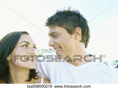 Young couple gazing at each other View Large Photo Image Stock Photo - Young couple gazing at each other. Fotosearch