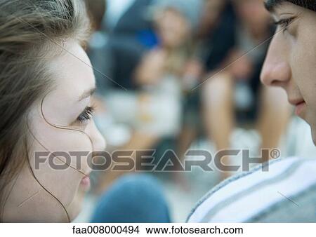 Young couple looking at each other, extreme close-up View Large Photo Image Picture - Young couple looking at each other, extreme close-up. Fotosearch