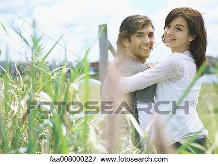 Young couple outdoors, tall weeds in foreground View Large Photo Image Stock Photo - Young couple outdoors, tall weeds in foreground. Fotosearch