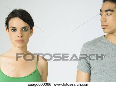 Young couple, woman looking at camera, man looking at woman View Large Photo Image Stock Photograph - Young couple, woman looking at camera, man looking at woman. Fotosearch