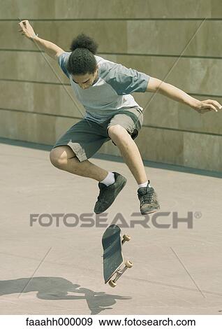 Young man doing trick on skateboard View Large Photo Image Stock Photo - Young man doing trick on skateboard. Fotosearch