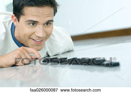 Young man knocking over row of dominoes, close-up View Large Photo Image Stock Photo - Young man knocking over row of dominoes, close-up. Fotosearch