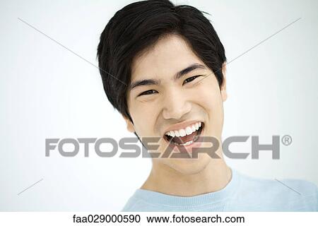 Stock Image - Young man laughing, portrait. Fotosearch