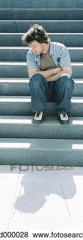 Young man sitting on steps View Large Photo Image Stock Photo - Young man sitting on steps. Fotosearch