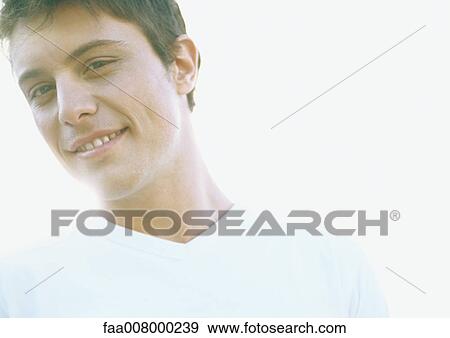 Young man smiling, backlit View Large Photo Image Stock Photo - Young man smiling, backlit. Fotosearch