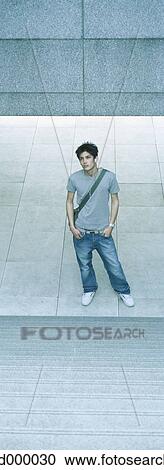 Young man standing at bottom of steps with hands in pockets View Large Photo Image Stock Image - Young man standing at bottom of steps with hands in pockets. Fotosearch