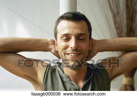 Young man with hands behind head and eyes closed View Large Photo Image Stock Photo - Young man with hands behind head and eyes closed. Fotosearch