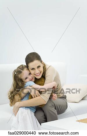 Young mother hugging little girl, smiling at camera View Large Photo Image Stock Image - Young mother hugging little girl, smiling at camera. Fotosearch