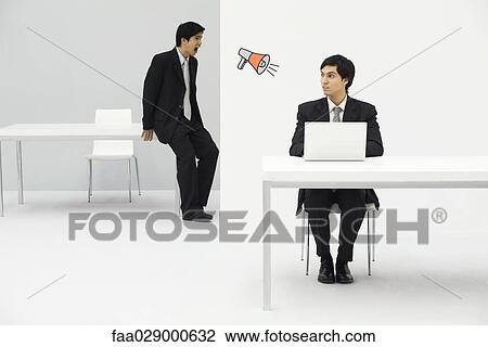 Young professional sitting in office, looking at megaphone, colleague in the next room, shouting View Large Photo Image Stock Image - Young professional sitting in office, looking at megaphone, colleague in the next room, shouting. Fotosearch
