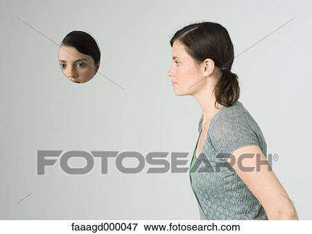 Stock Photo - Young woman and face reflected in mirror. Fotosearch